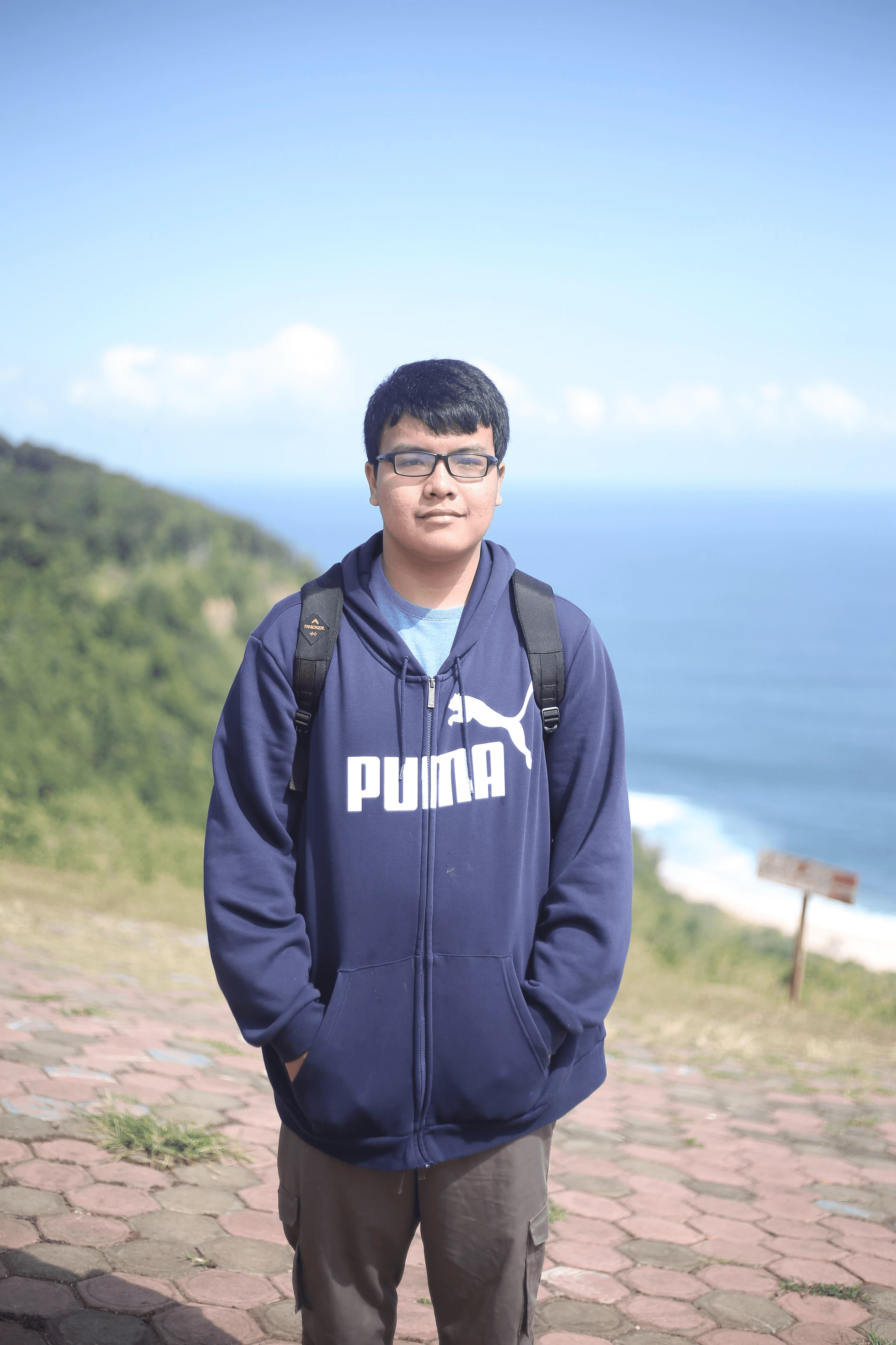 Ahsan standing on a hillside above the sea